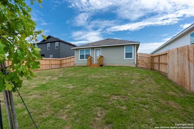 a view of a backyard with wooden fence