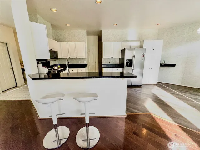 a kitchen with granite countertop a sink stainless steel appliances and a window