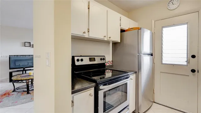 a kitchen with stainless steel appliances granite countertop a refrigerator and a stove top oven