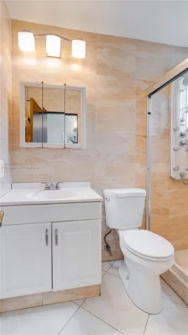 a bathroom with a granite countertop toilet sink mirror and