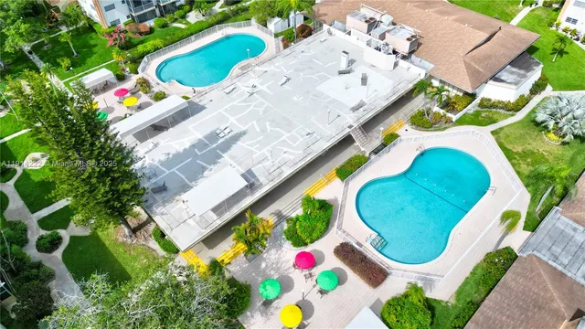 aerial view of a swimming pool with a yard and outdoor seating