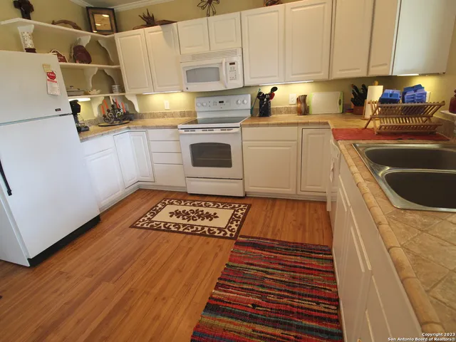 a kitchen with granite countertop a stove a sink and a refrigerator