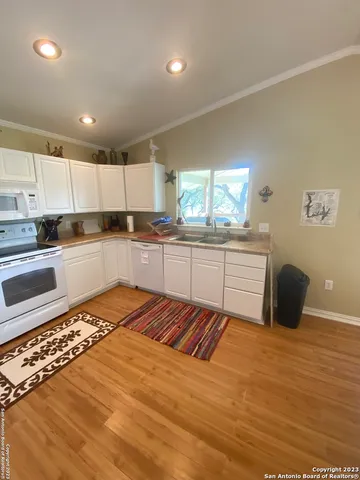 a large kitchen with stainless steel appliances granite countertop a sink and cabinets