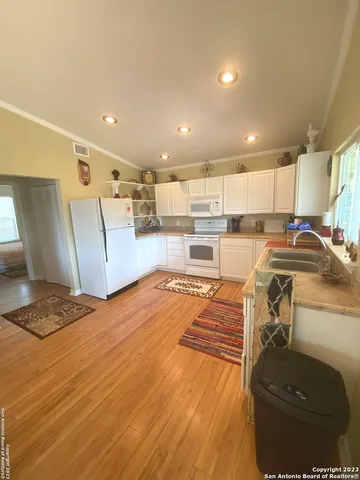 a kitchen with stainless steel appliances granite countertop a sink refrigerator and cabinets