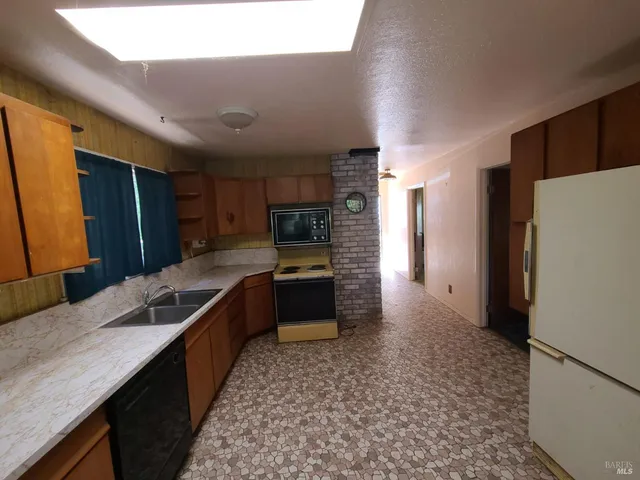 a kitchen with stainless steel appliances granite countertop a sink stove and microwave