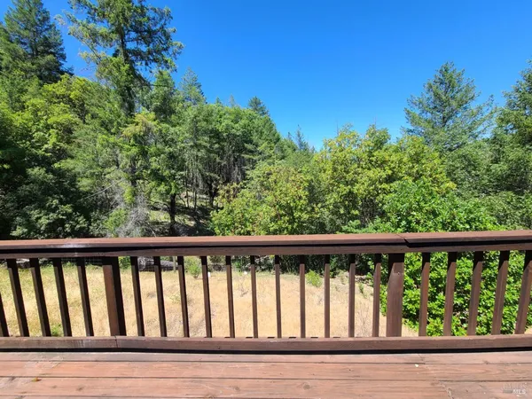 a view of balcony with wooden floor and fence