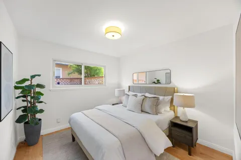 a bedroom with a bed and a potted plant