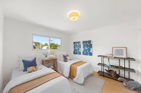 a bedroom with two beds and a potted plant