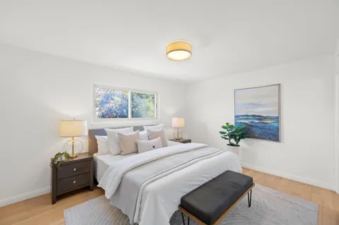 a bedroom with a bed and a painting on the wall