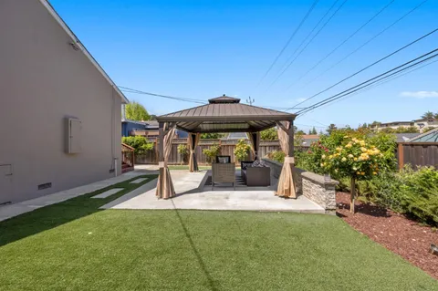 a view of a patio with a table and chairs under an umbrella