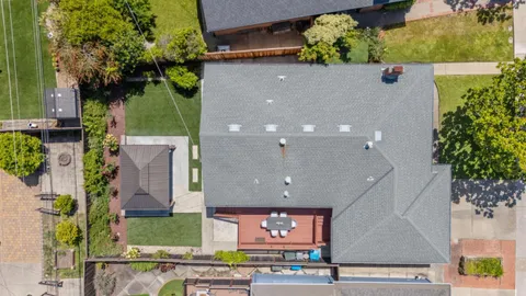 an aerial view of a house with a yard and potted plants