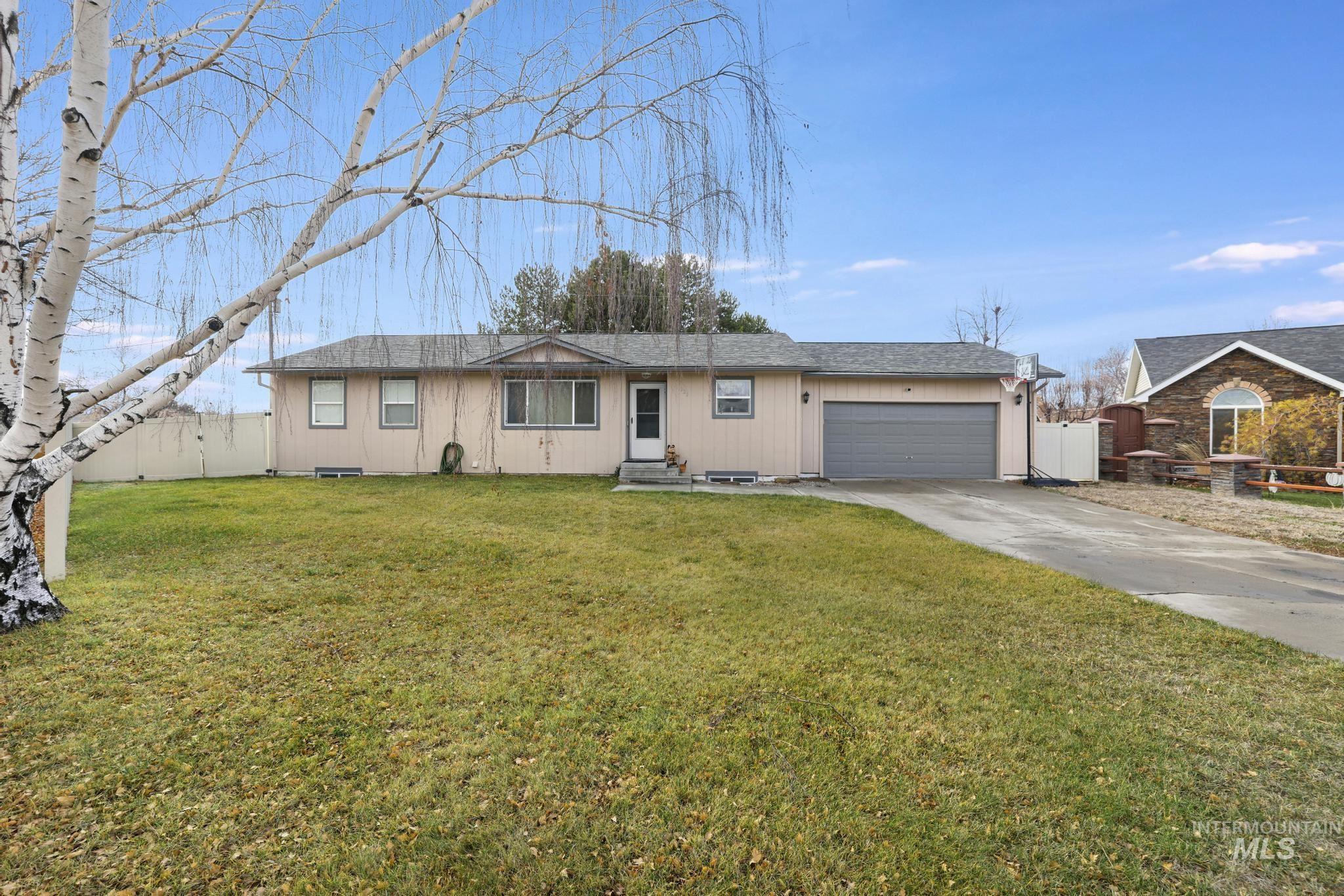 Ranch-style home with concrete driveway, a garage, and a shingled roof