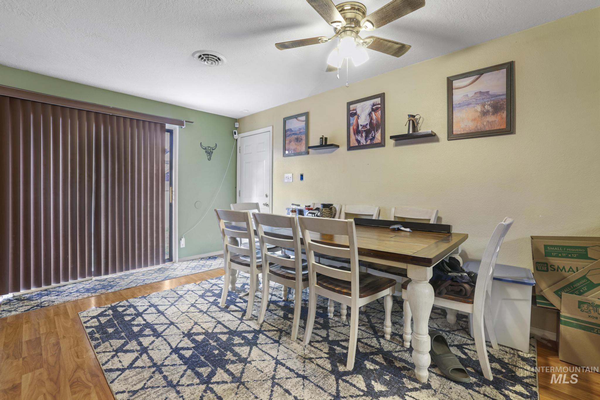 721 Beta Circle Twin Falls, ID 83301 - Photo 11 of 28 Dining area featuring light wood-style floors, a textured ceiling, and a ceiling fan