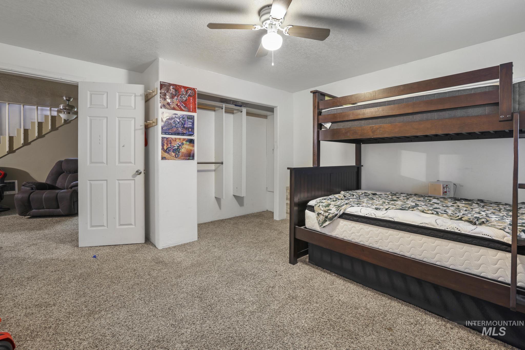 721 Beta Circle Twin Falls, ID 83301 - Photo 26 of 28 Bedroom featuring carpet, a textured ceiling, a ceiling fan, and a closet