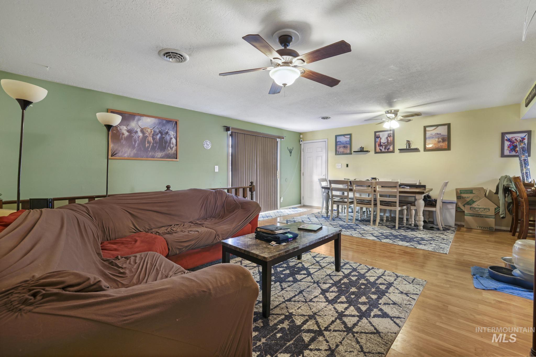 721 Beta Circle Twin Falls, ID 83301 - Photo 10 of 28 Living room featuring wood finished floors, a textured ceiling, and ceiling fan
