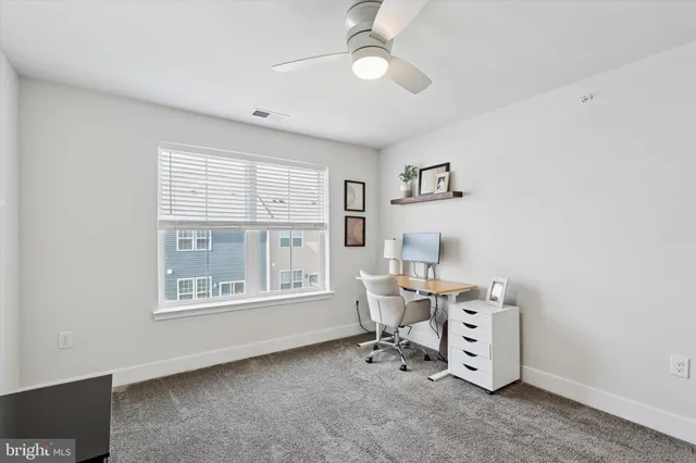 a view of a workspace with furniture and a window