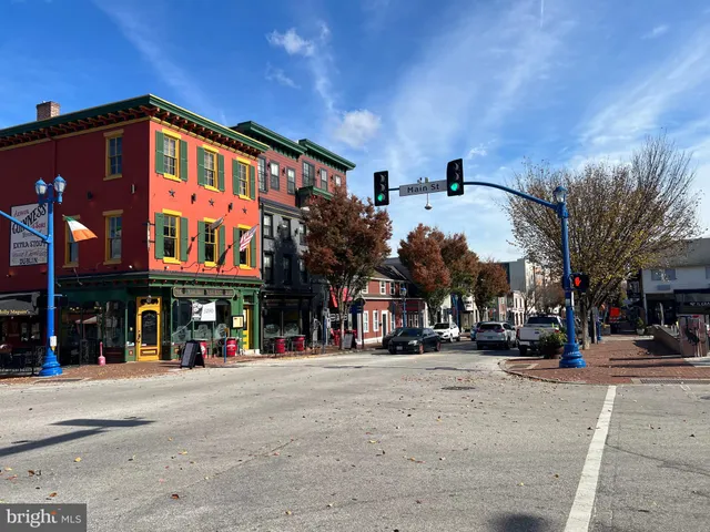 a front view of a building with lots of cars and trees