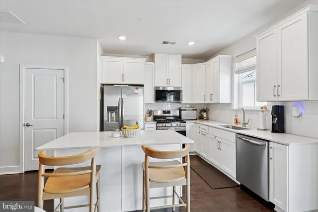 a kitchen with stainless steel appliances kitchen island granite countertop a sink and cabinets