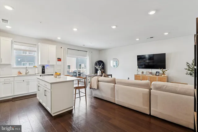 a living room with furniture flat screen tv and wooden floor