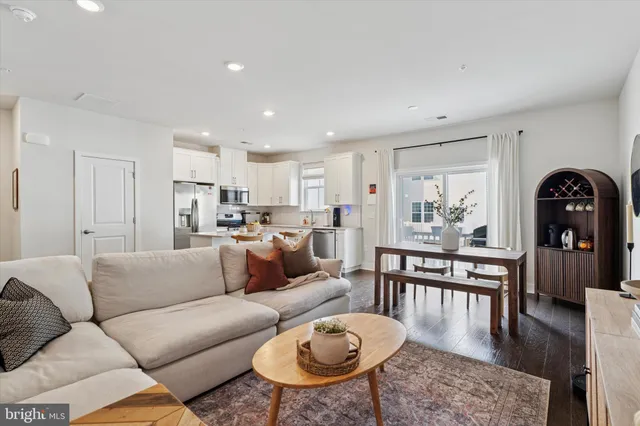 a living room with furniture wooden floor and a dining table