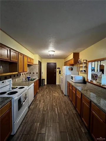 a large kitchen with stainless steel appliances granite countertop a lot of counter space and a sink