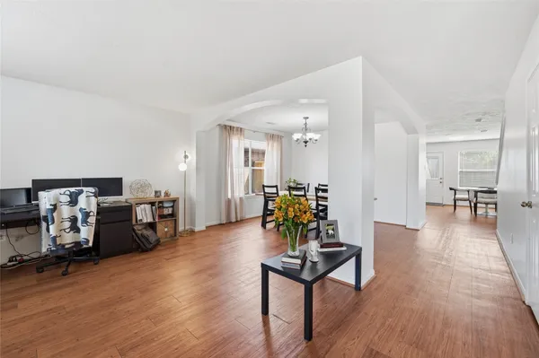 a living room with furniture and a wooden floor