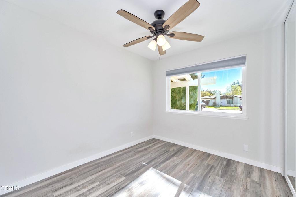 4895 Muirwood Court Simi Valley, CA 93063 - Photo 20 of 45 an empty room with wooden floor fan and windows