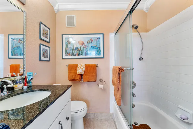 a bathroom with a granite countertop tub sink and a large mirror
