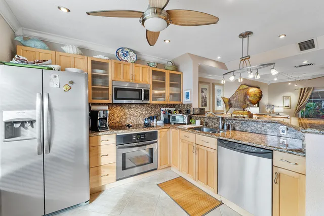 a kitchen with stainless steel appliances granite countertop a sink a stove and refrigerator