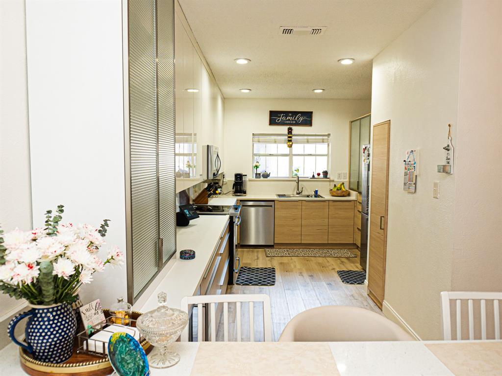5310 Keller Springs Road, Unit 711 Dallas, TX 75248 - Photo 3 of 20 a kitchen with kitchen island stainless steel appliances a sink cabinets and living room view