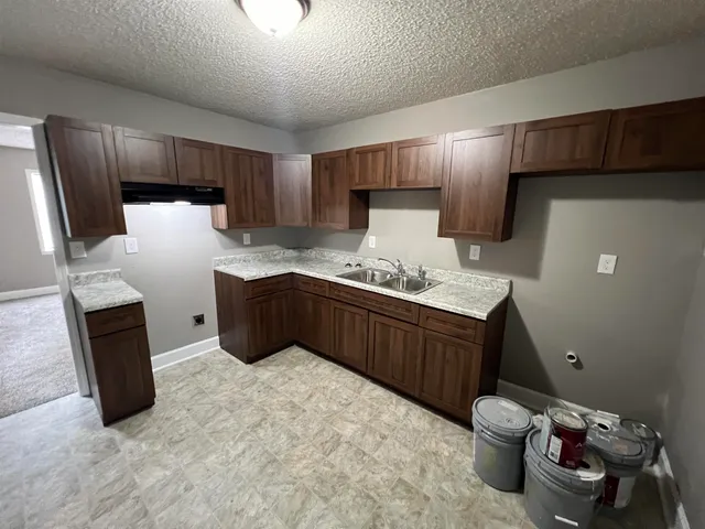 a kitchen with stainless steel appliances a refrigerator and a more cabinets