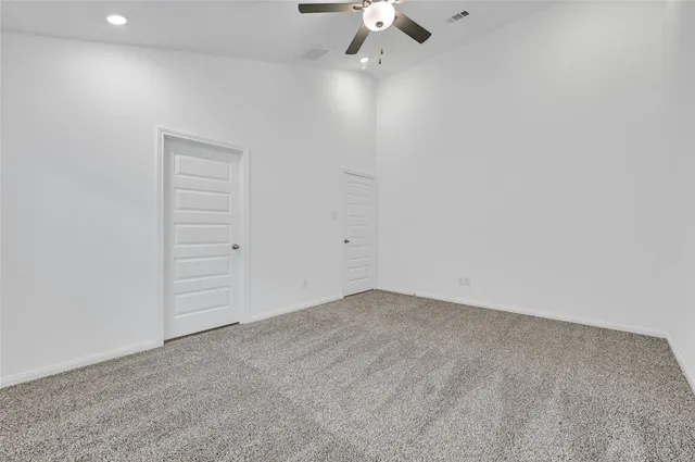 an empty room with closet and fan