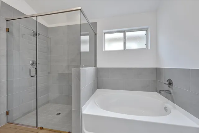 a white bath tub sitting next to a shower