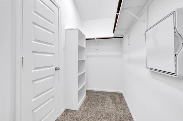 a view of walk in closet with empty racks