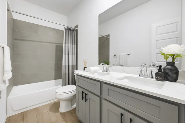 a bathroom with a granite countertop sink a toilet and shower
