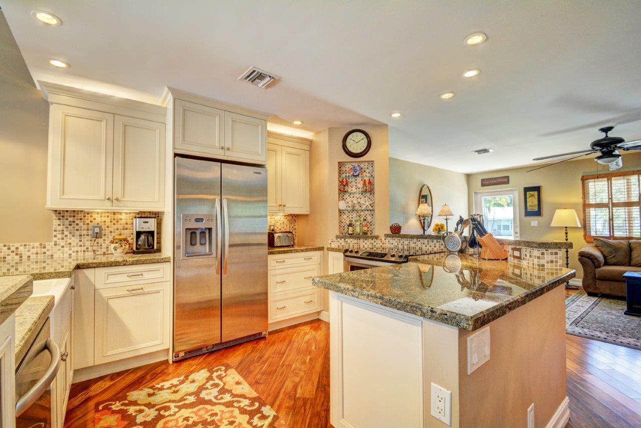 1135 Southwest 14th Street Boca Raton, FL 33486 - Photo 6 of 26 a kitchen with stainless steel appliances granite countertop a sink stove and refrigerator