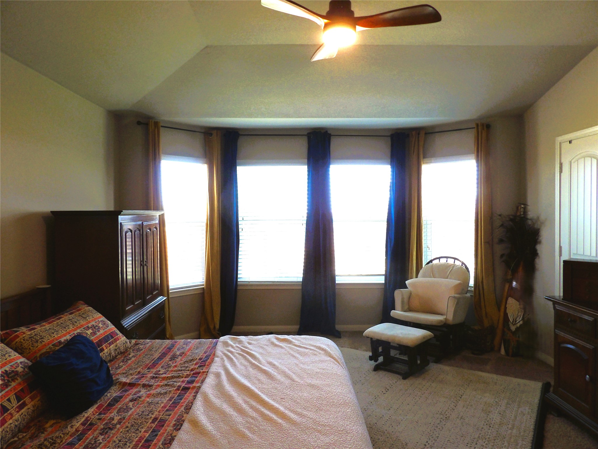 930 Pumpkin Ridge New Braunfels, TX 78130 - Photo 18 of 32 Recessed tray ceiling with a built-in ceiling fan, bay windows with blinds, and light neutral wall paint