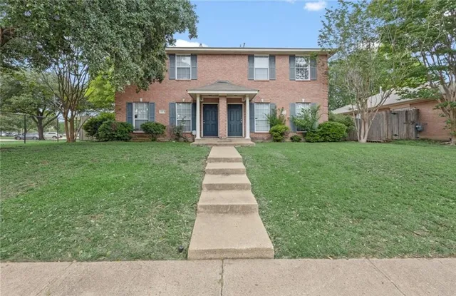 front view of a house and a yard and trees