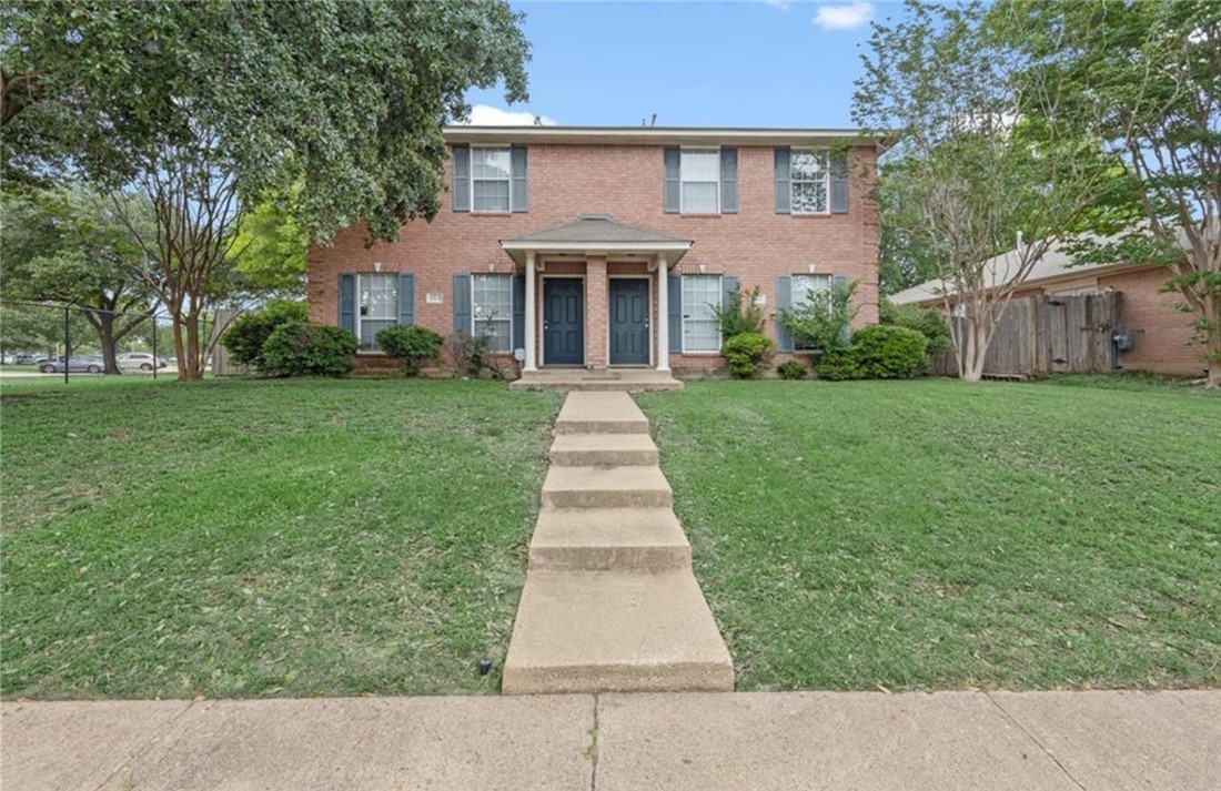 front view of a house and a yard and trees