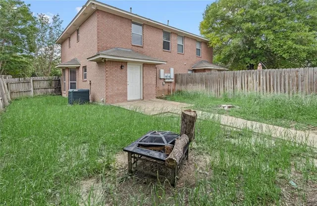 a view of a backyard with table and chairs and wooden fence