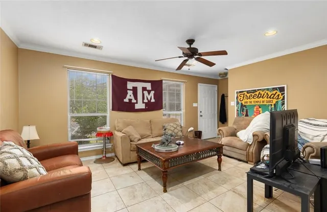 a living room with furniture a ceiling fan and a window