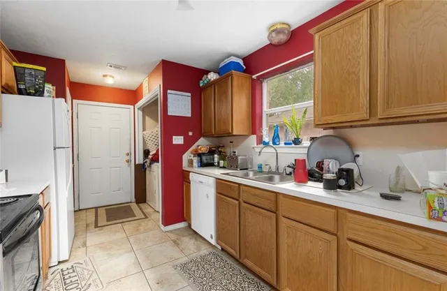 a kitchen with stainless steel appliances a sink cabinets and a window