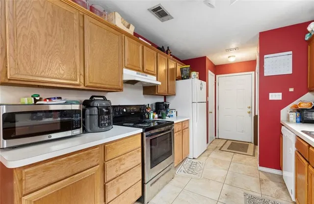 a kitchen with stainless steel appliances granite countertop a refrigerator and a stove top oven