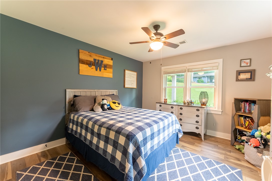103 Riggs Drive Clemson, SC 29631 - Photo 28 of 50 Hardwood floors and a ceiling fan enhance this cozy bedroom, offering comfort and style.