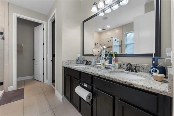 a bathroom with a granite countertop sink double vanity and a mirror
