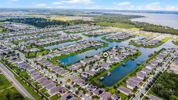 an aerial view of a city with lots of residential buildings ocean and mountain view in back