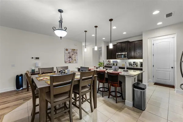 a kitchen with a dining table cabinets and stainless steel appliances