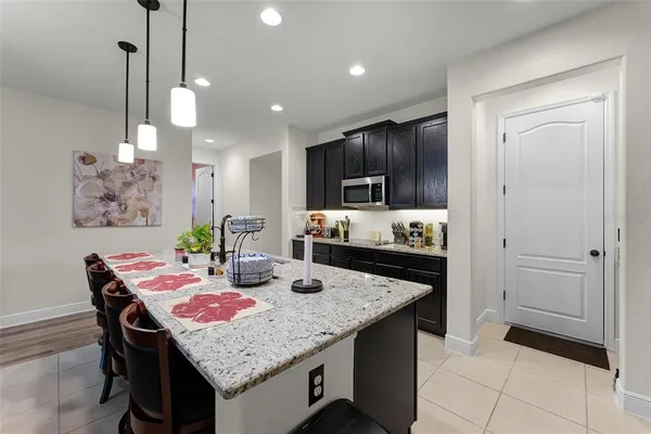 a kitchen with granite countertop kitchen island stainless steel appliances a stove center island a table and chairs in it