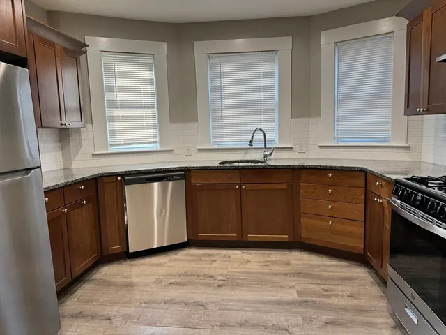 a kitchen with stainless steel appliances granite countertop a sink stove and refrigerator
