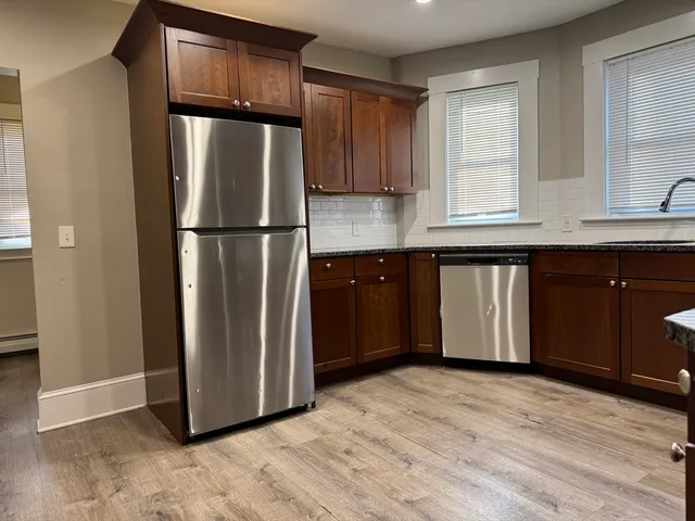 a kitchen with stainless steel appliances granite countertop a refrigerator and a sink